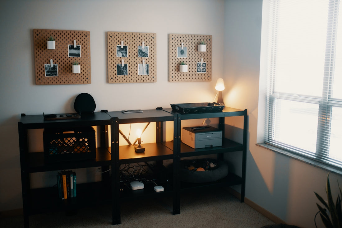 a desk with a lamp and pictures on the wall