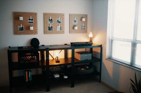 a desk with a lamp and pictures on the wall