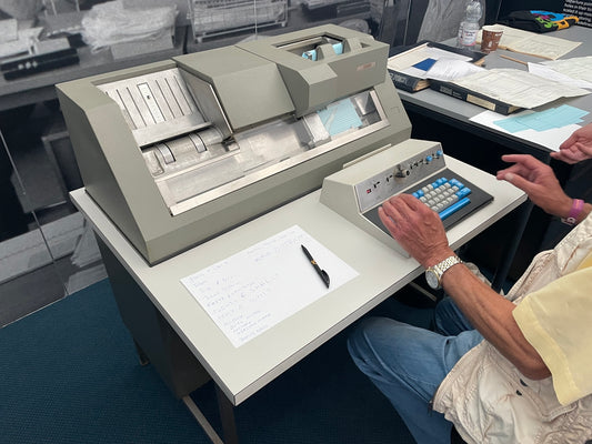 a person sitting at a desk with a computer and papers
