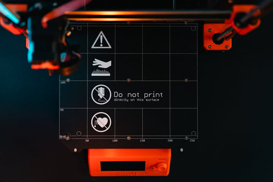 3D printer build plate with warning symbols