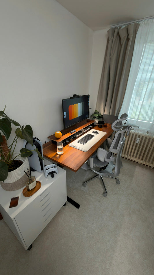 Modern home office desk setup with computer and chair.