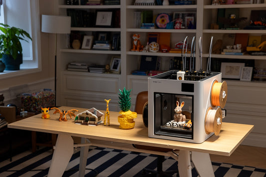 3D printer with filament and printed objects on desk
