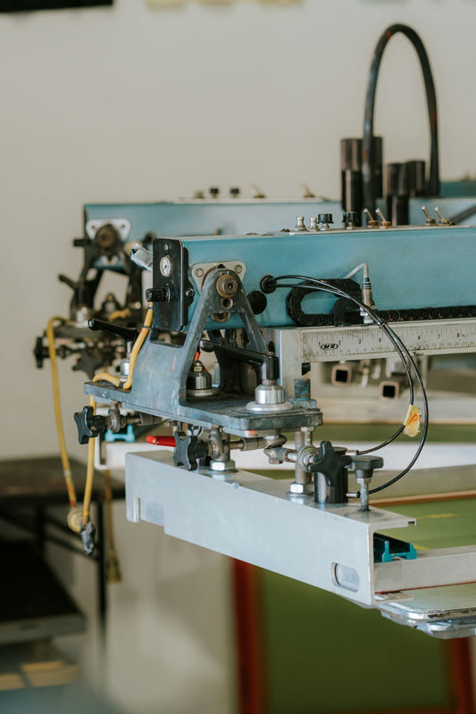 Close-up of a screen printing machine in a workshop.